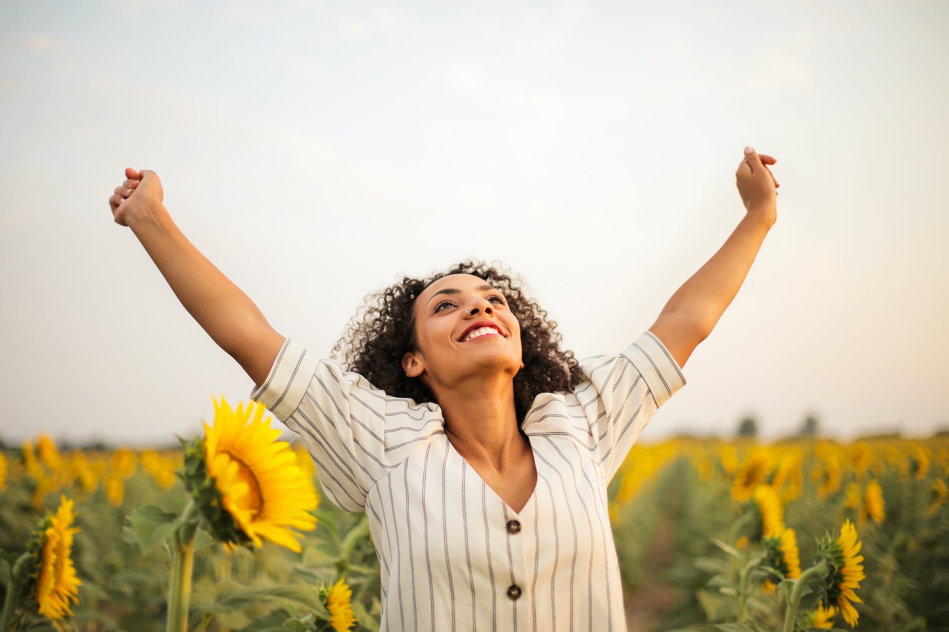 woman-celebrating-achievement-success-in-field-of-sunflowers